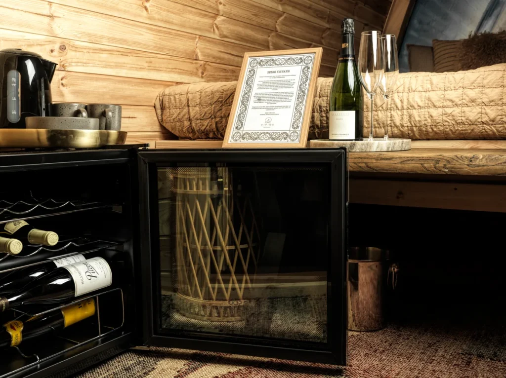 Minibar med vinkøleskab Minibar med vinkøleskab, champagne og kaffesæt i en overnatningshytte på Bramslev Bakker